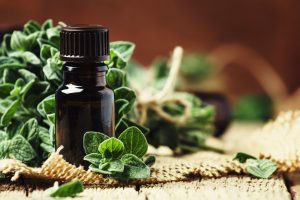 Flacon d'huile essentielle avec de l'origan frais