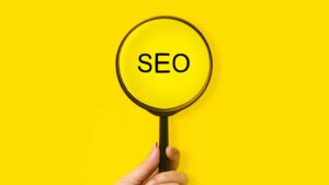 le mot "SEO" écrit sur un fond jaune avec une loupe devant