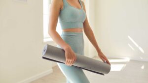 Femme qui prépare son sport à la maison avec son tapis en mousse